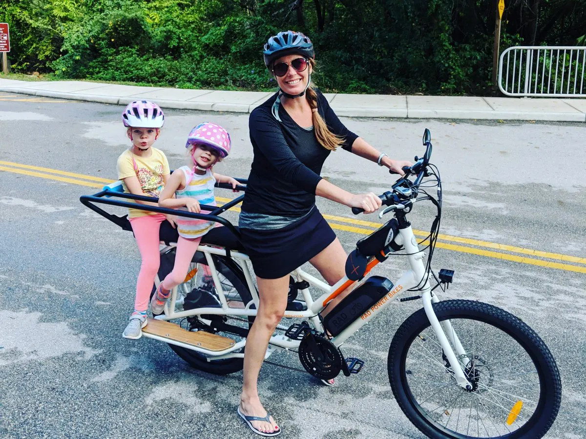 Kelly Carr riding a Rad Power cargo e-bike with her kids in Naples